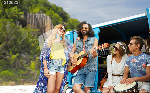 Image of hippie friends playing music at minivan on island