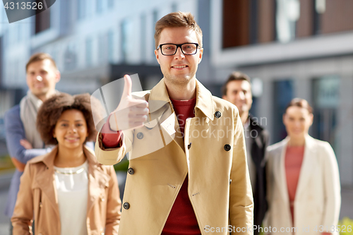Image of happy smiling man showing thumbs up outdoors