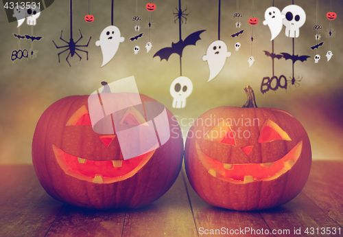 Image of carved pumpkins in witch hat and halloween garland