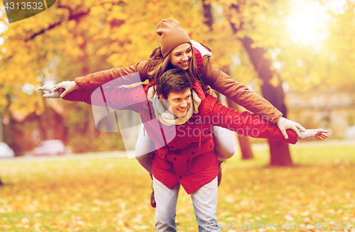 Image of happy young couple having fun in autumn park