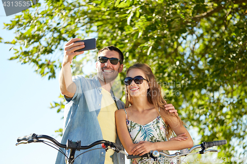 Image of couple with bicycles taking selfie by smartphone