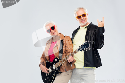 Image of senior couple with guitar showing rock hand sign