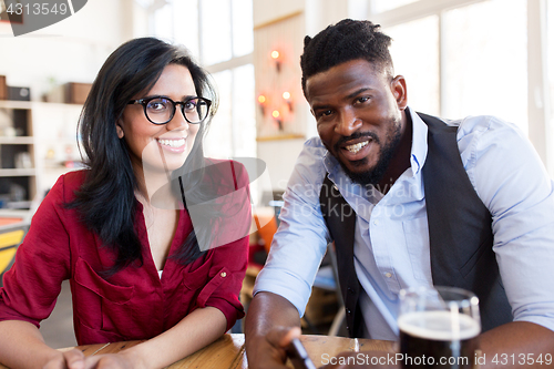 Image of happy man and woman with smartphone at bar