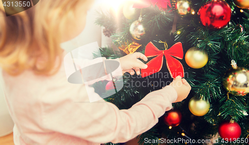 Image of close up of little girl decorating christmas tree