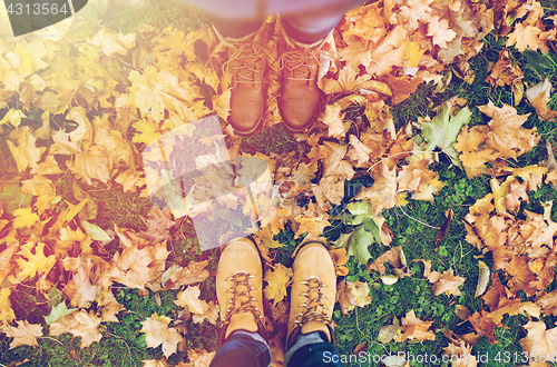 Image of couple of feet in boots and autumn leaves