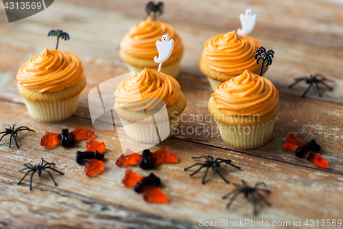 Image of halloween party decorated cupcakes on wooden table