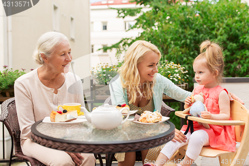 Image of woman with daughter and senior mother at cafe