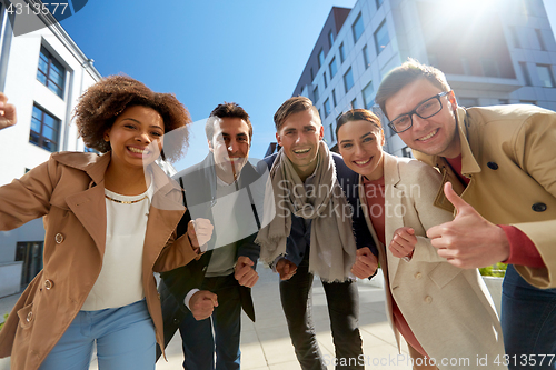 Image of group of people showing thumbs up in city