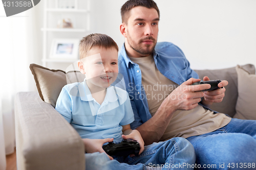 Image of father and son playing video game at home