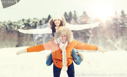 Image of happy couple having fun over winter background