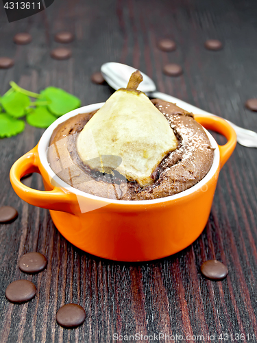 Image of Cake chocolate with pear in red bowl on dark board