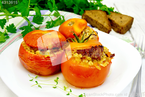 Image of Tomatoes stuffed with bulgur and meat in plate on table