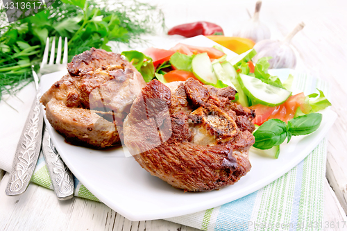 Image of Turkey steak roasted with vegetables in plate on board