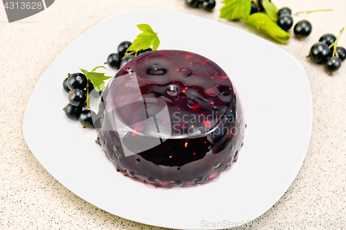 Image of Jelly from black currant with berries in plate on granite table