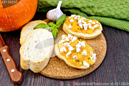 Image of Bruschetta with pumpkin and basil on board