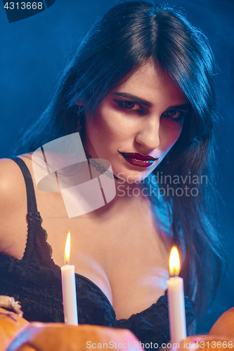 Image of Beautiful witch with Halloween pumpkins