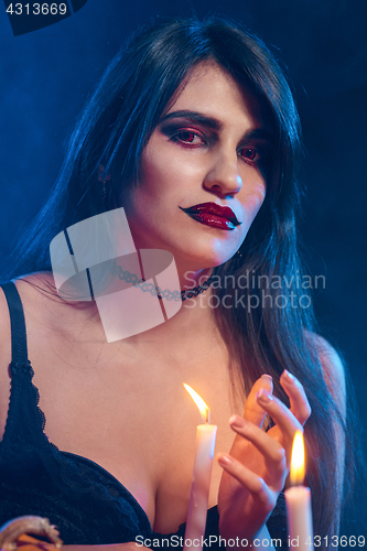 Image of Beautiful witch with Halloween pumpkins