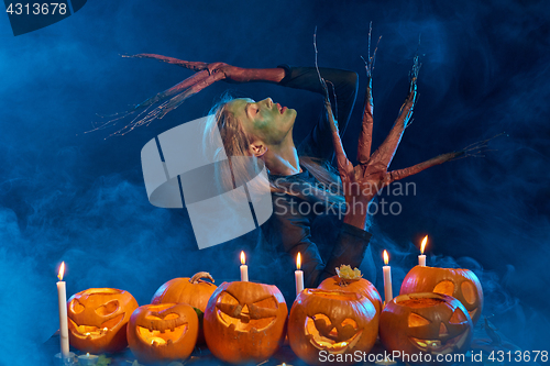 Image of Halloween costume woman, tree girl with pumpkins