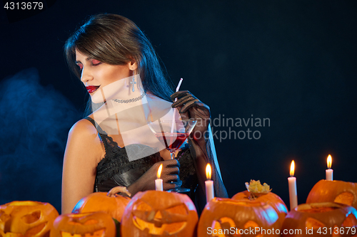 Image of Sensual witch holding cocktail glass