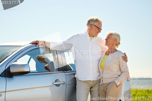 Image of happy senior couple at car in summer