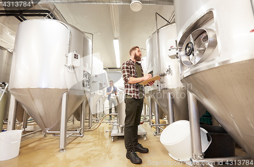 Image of men with clipboard at craft brewery or beer plant