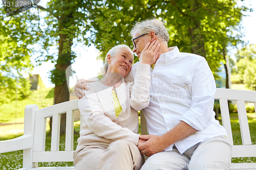 Image of happy senior couple hugging in city park