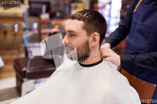 Image of hairdresser and man with beard at barbershop