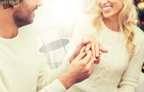 Image of man giving diamond ring to woman for christmas