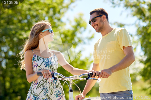 Image of happy couple with bicycle at country