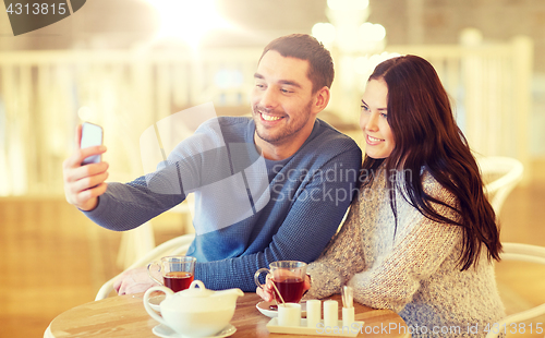 Image of couple taking smartphone selfie at cafe restaurant