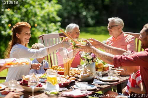 Image of happy family having dinner or summer garden party