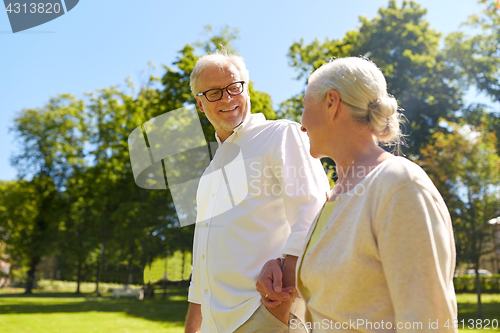 Image of happy senior couple walking at summer city park