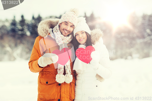 Image of happy couple with red hearts over winter landscape