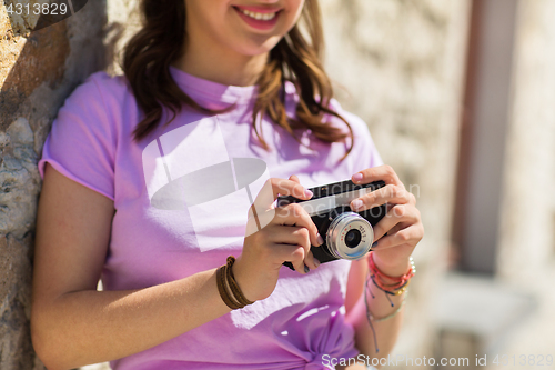 Image of close up of woman with vintage camera outdoors