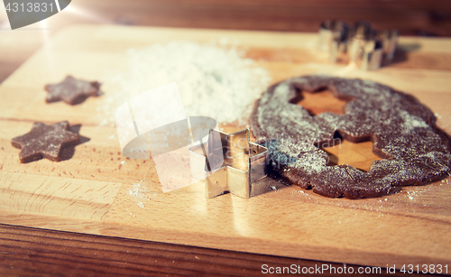 Image of close up of ginger dough, molds and flour on board