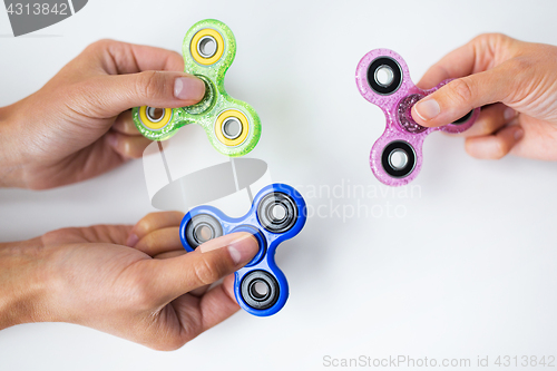 Image of close up of hands playing with fidget spinners