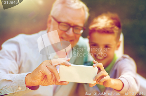 Image of old man and boy taking selfie by smartphone