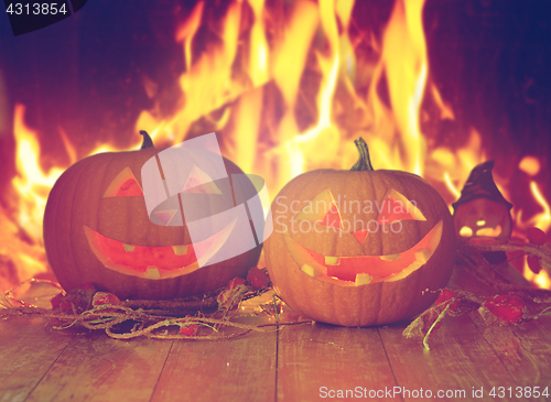 Image of carved halloween pumpkins on table over fire