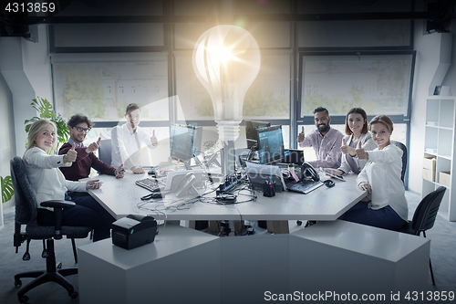 Image of business team showing thumbs up at office