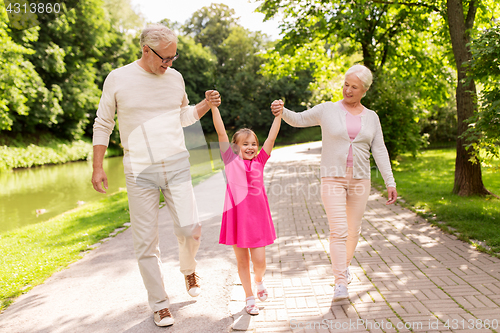 Image of senior grandparents and granddaughter at park