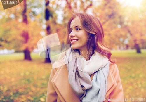 Image of beautiful happy young woman smiling in autumn park