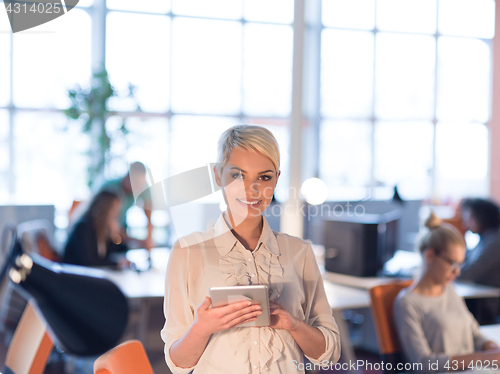 Image of woman working on digital tablet in night office