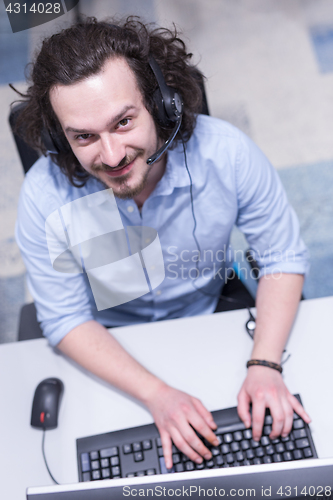 Image of male call centre operator doing his job top view