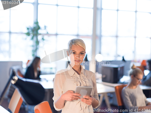 Image of woman working on digital tablet in night office