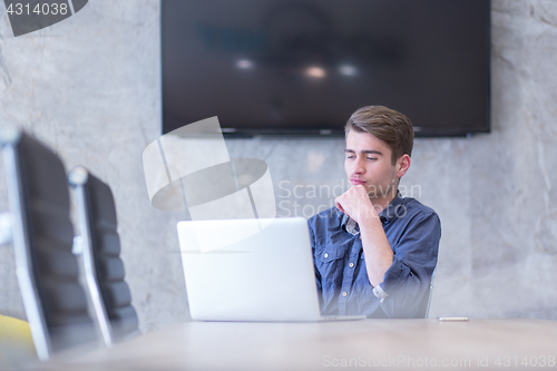 Image of businessman working using a laptop in startup office