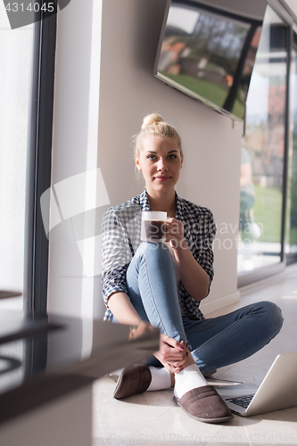 Image of young woman drinking coffee enjoying relaxing lifestyle