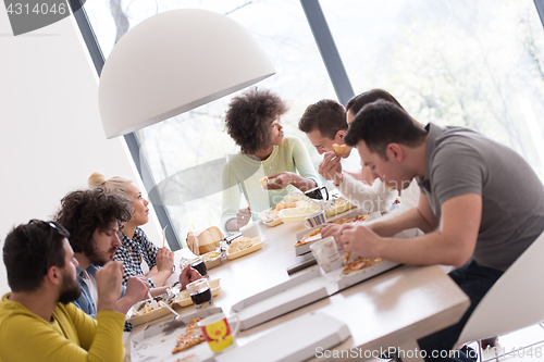 Image of multiethnic group of happy friends lunch time