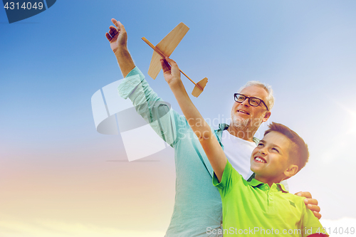 Image of senior man and boy with toy airplane over sky