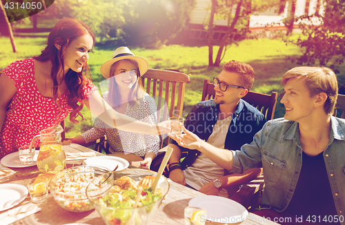 Image of happy friends having dinner at summer garden party