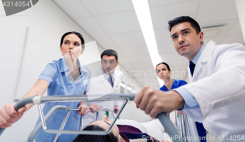 Image of medics with woman on hospital gurney at emergency